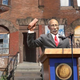 Mayor David Bing christens the brand-new housing development by shattering the window of a dilapidated tenement building.